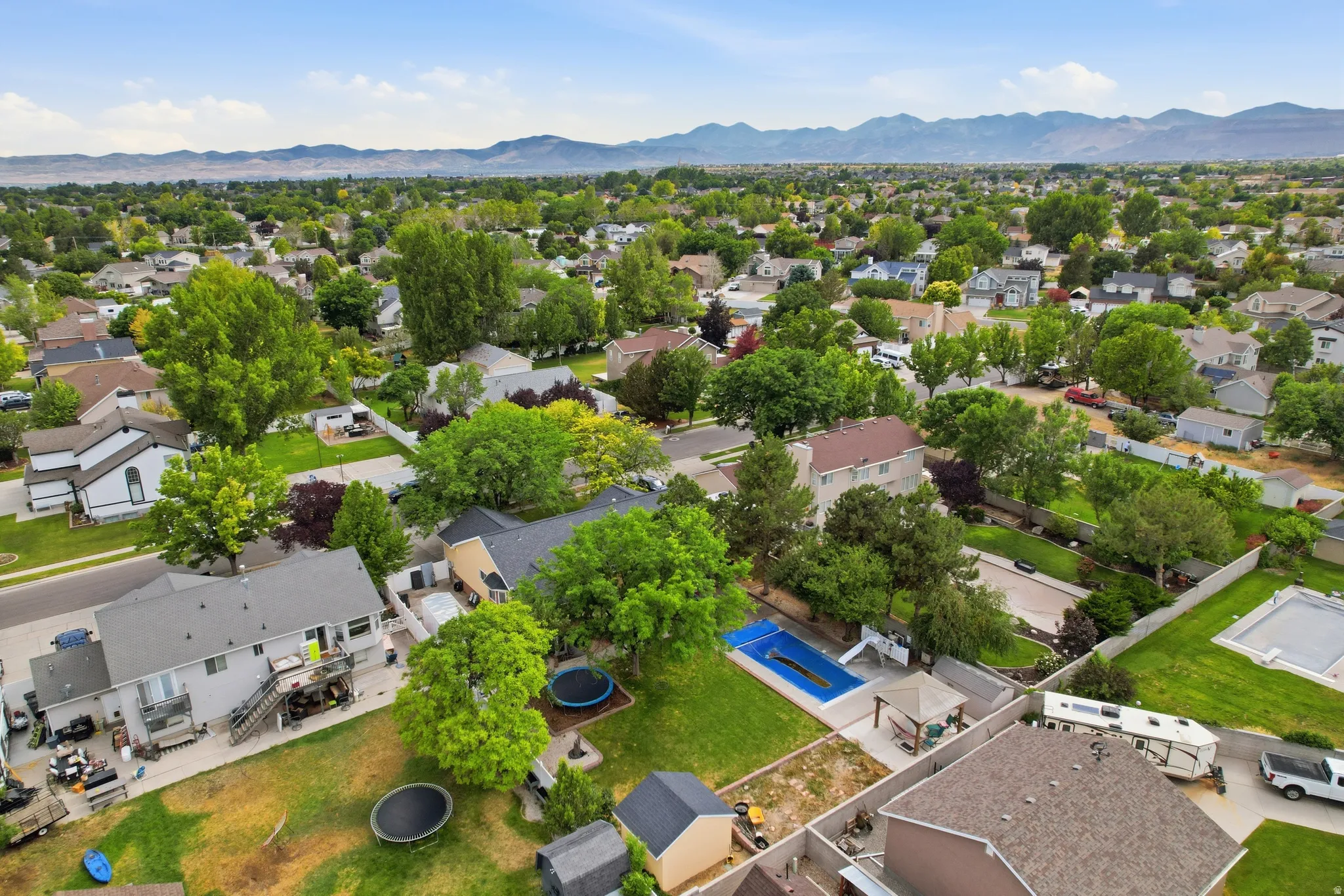 Expansive neighborhood with mature trees and mountain scenery