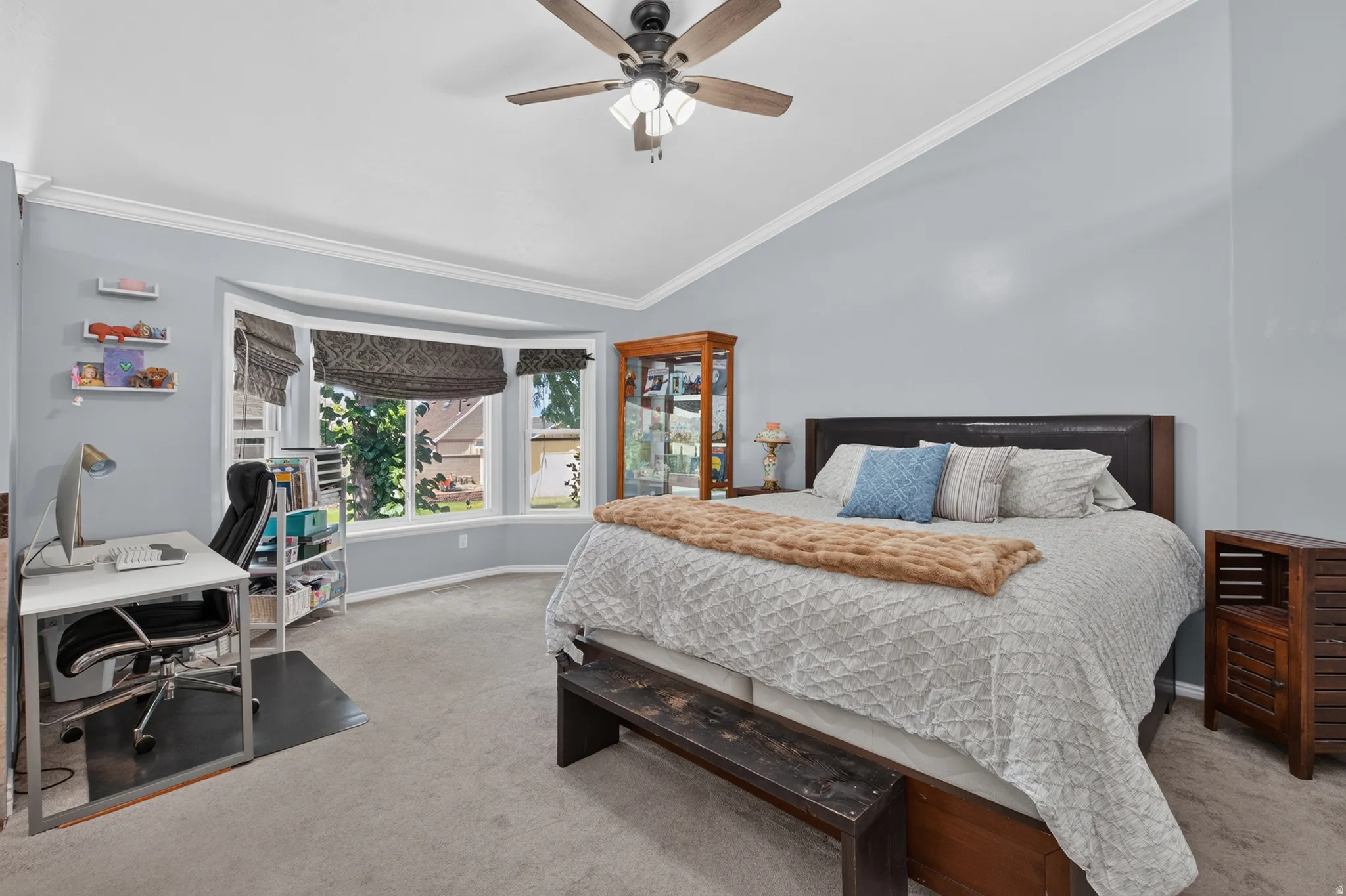 Spacious room featuring a bay window, crown molding, and a ceiling fan