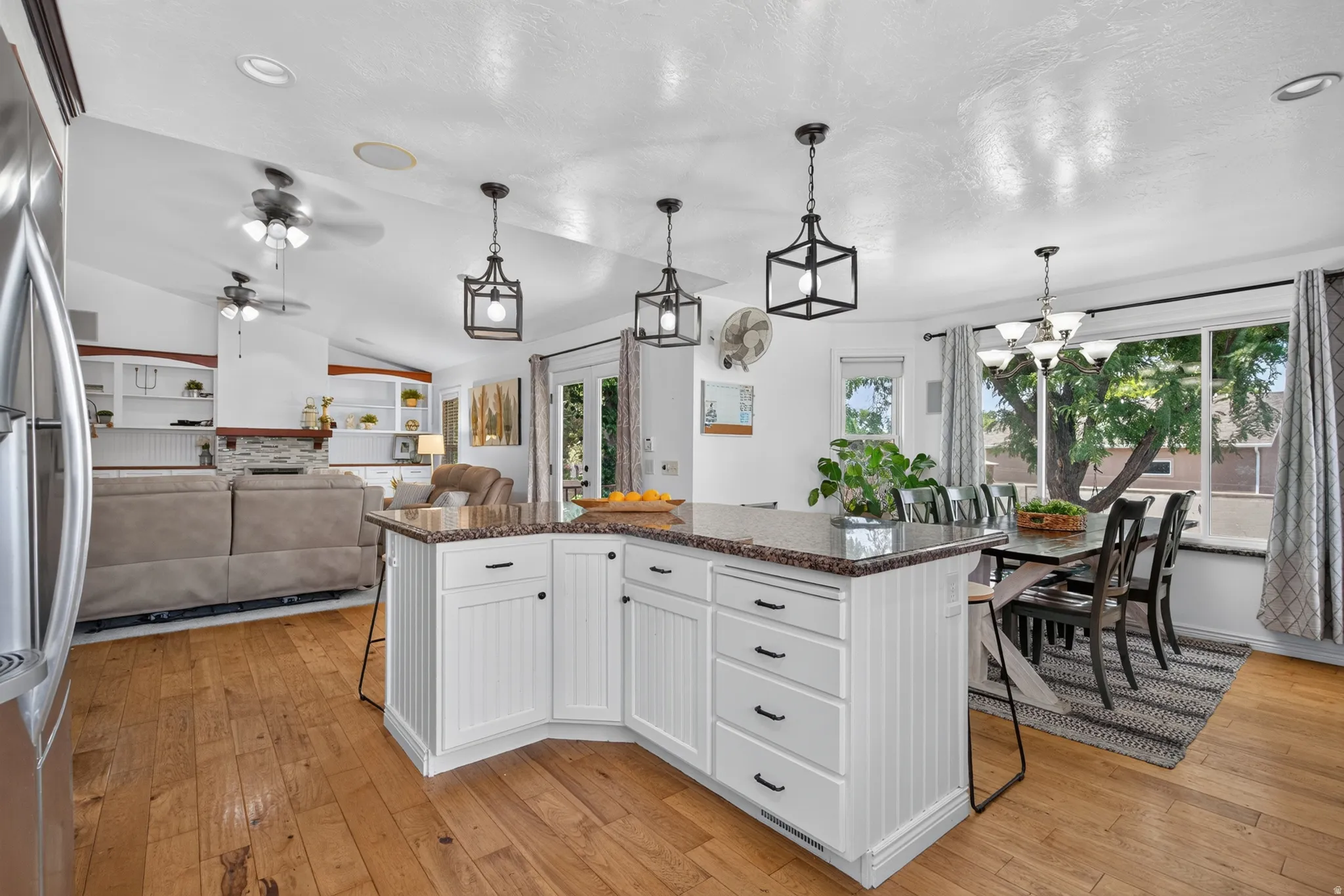 Kitchen island with a speckled countertop, white beadboard paneling, and black hardware