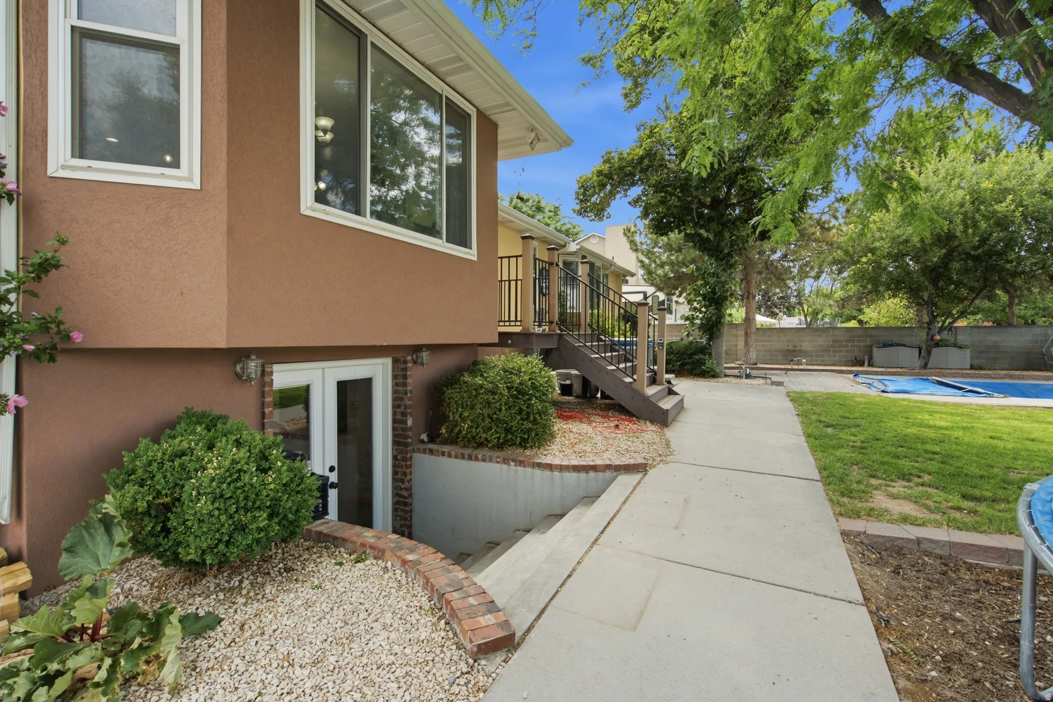 Exterior stucco finish with white trim windows and a walk-out basement entrance