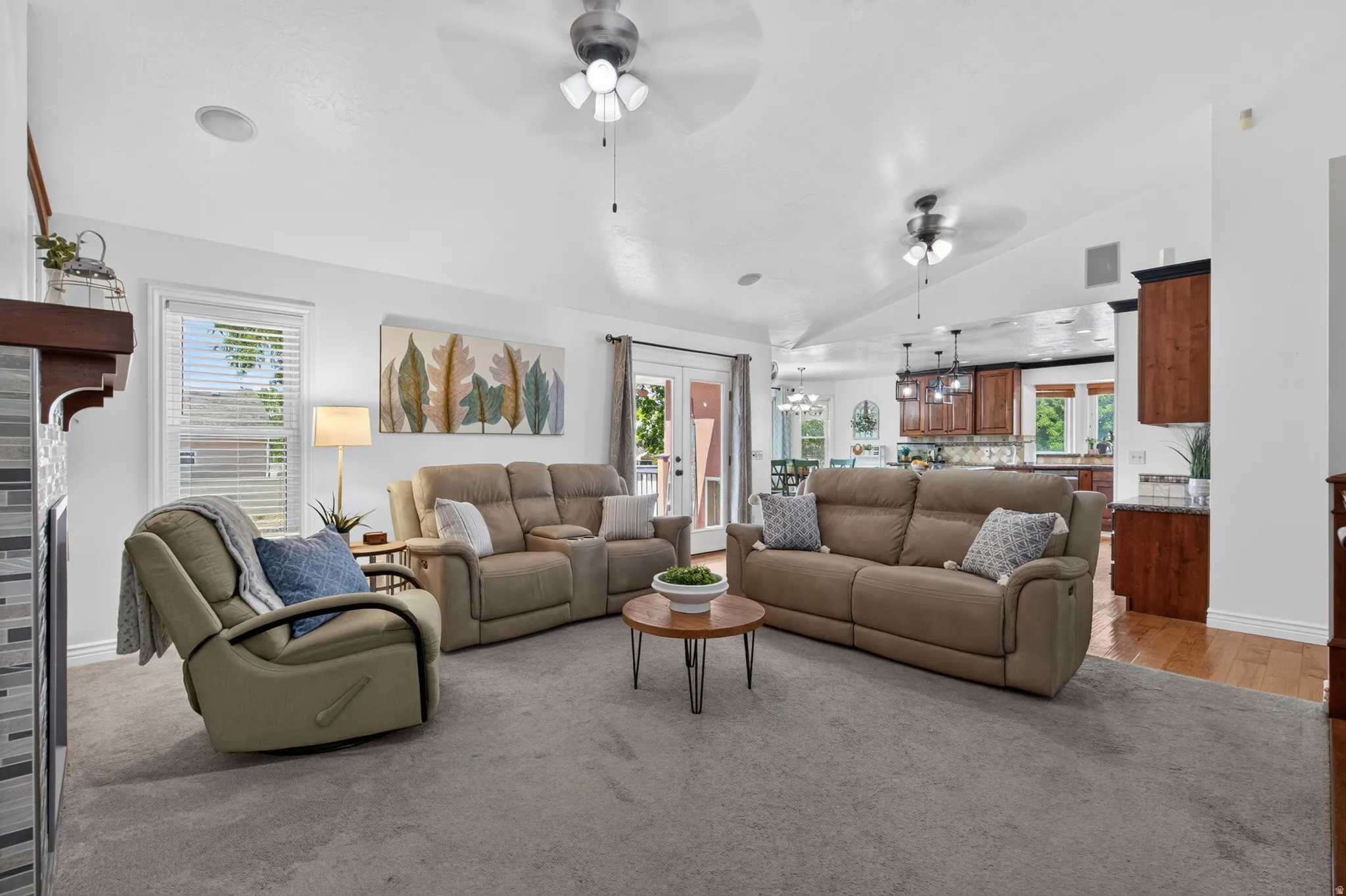 Spacious living area featuring vaulted ceilings, recessed lighting, and dual ceiling fans