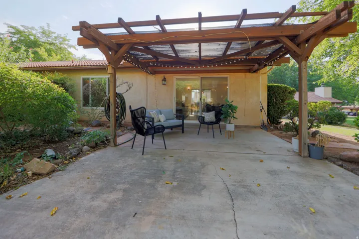Concrete patio with an overhead wooden pergola