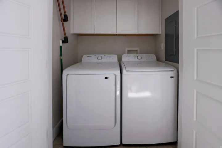 Dedicated laundry area with built-in cabinetry and hard surface flooring