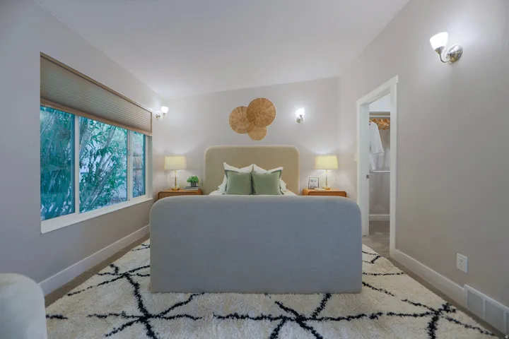 Recessed lighting, wall sconces, window with blinds, and an open doorway revealing a closet with built-in shelving