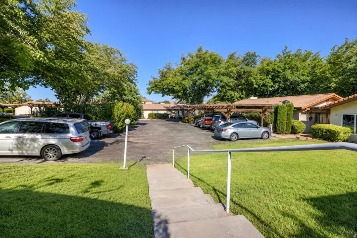 Private parking area featuring carports with wood-finish pergolas