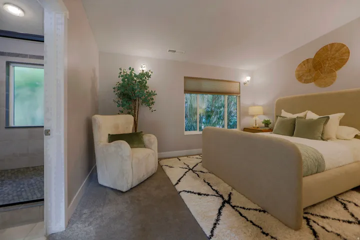 Recessed ceiling lighting, wall sconces, window with roller shade, and broadloom carpeting