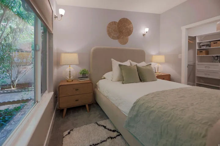 Window with exterior landscape, built-in closet system, and sconce lighting