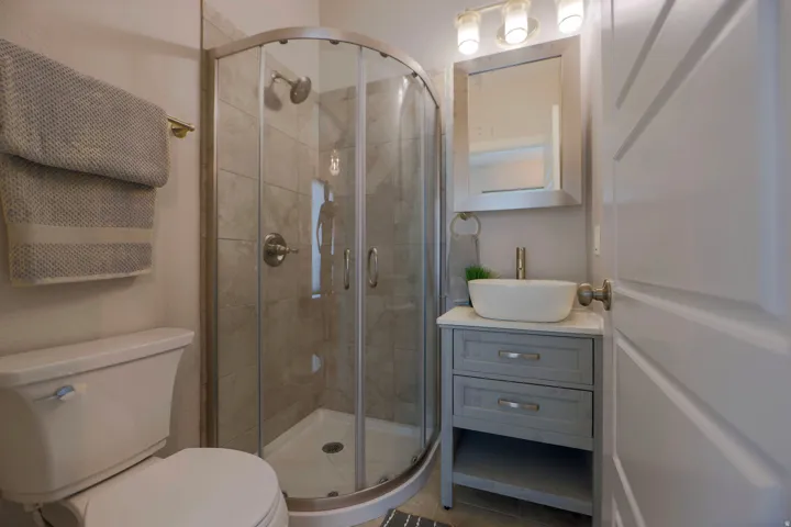 Shower with curved glass enclosure and tiled surround