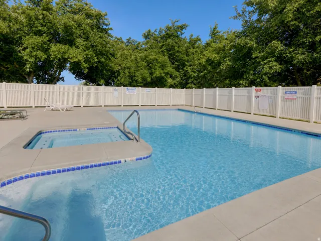 Swimming pool with integrated spa and concrete surround