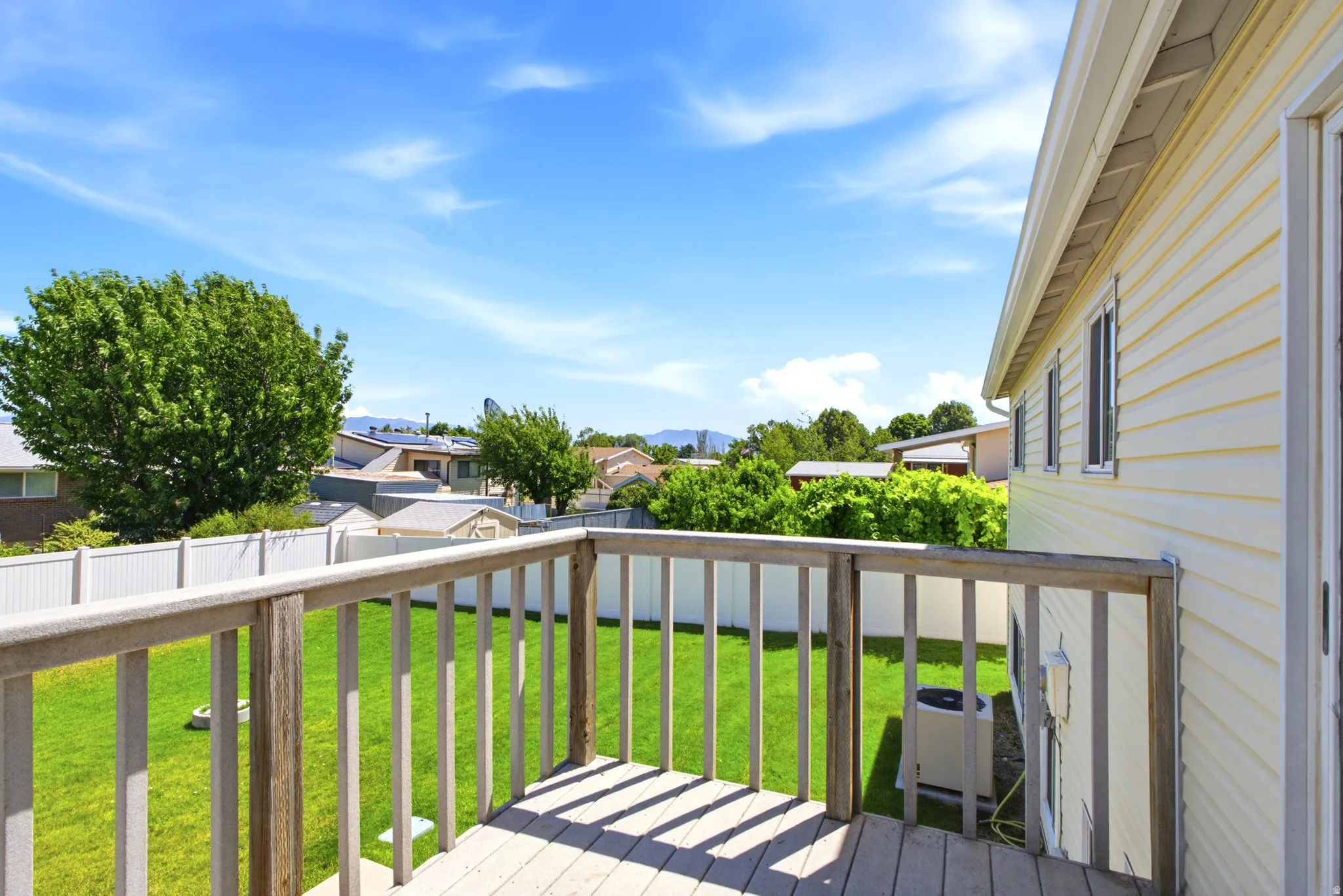 Upper-level wood deck overlooking a green lawn