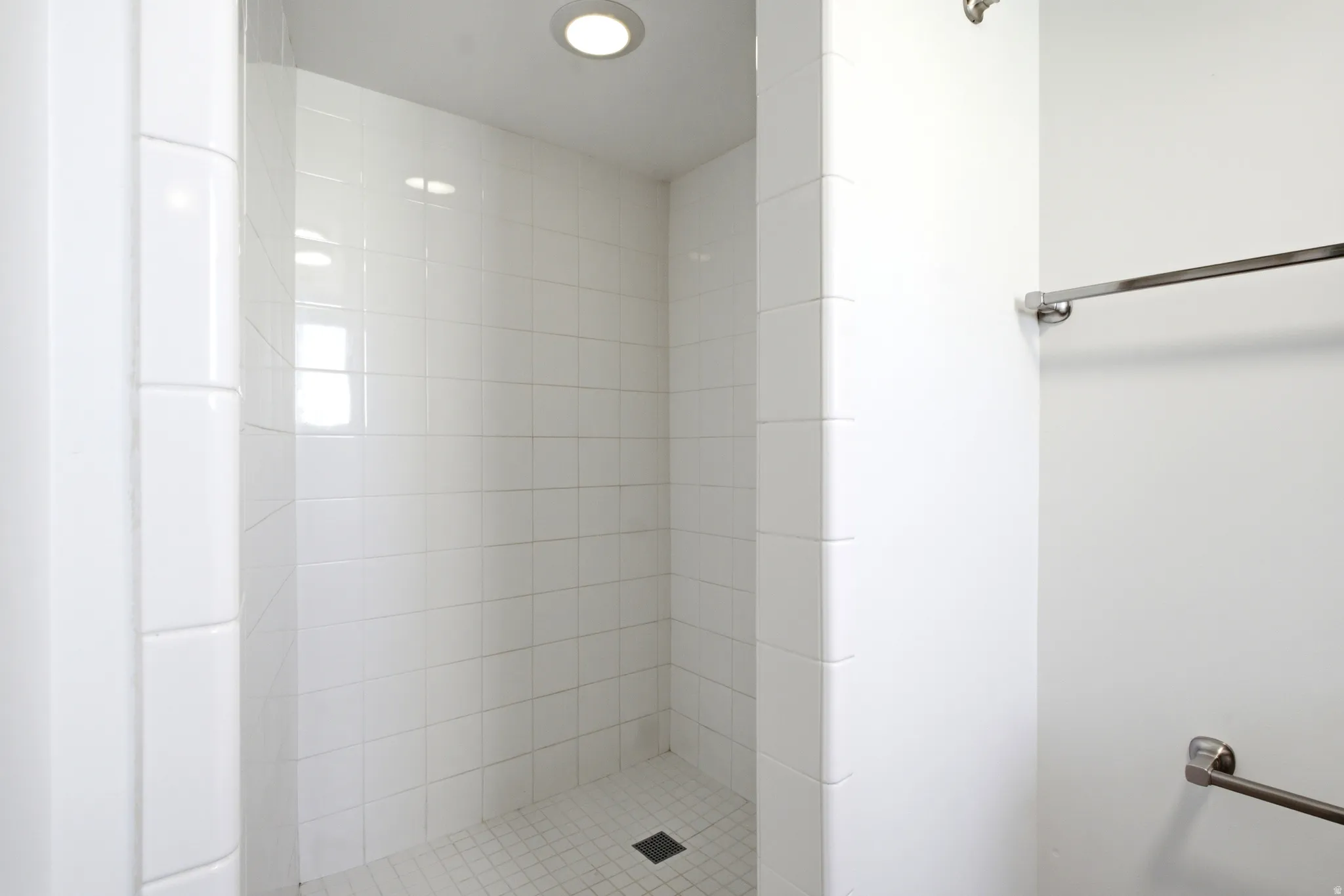 Shower with white ceramic subway tiles and recessed lighting