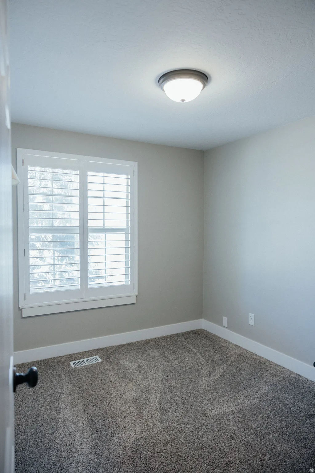 Bedroom two is just across from the bathroom and sits at the front of the house with beautiful plantation shutters.