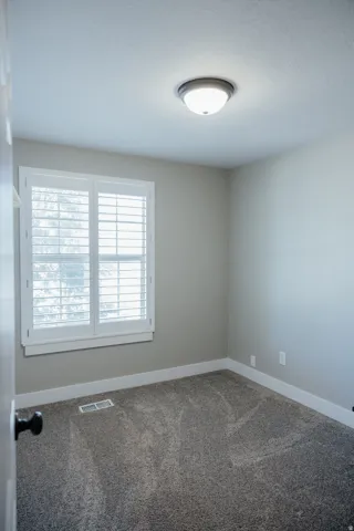 Bedroom two is just across from the bathroom and sits at the front of the house with beautiful plantation shutters.