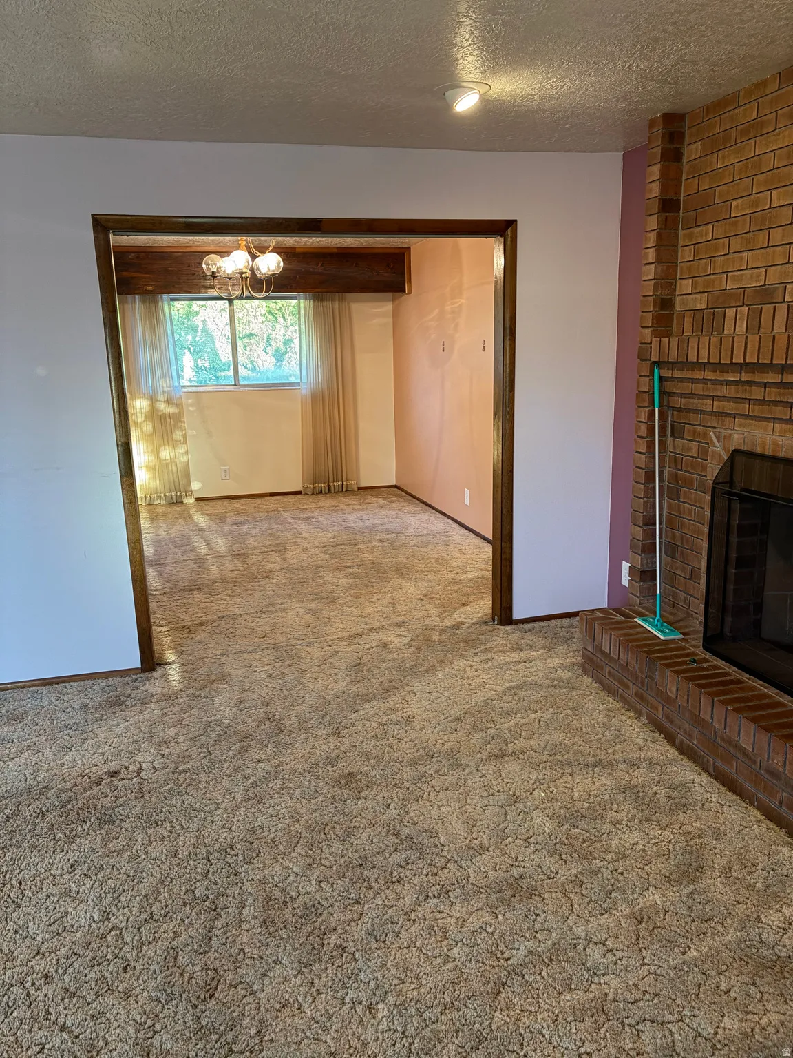 Brick fireplace with hearth, recessed lighting, and wood-trimmed doorway
