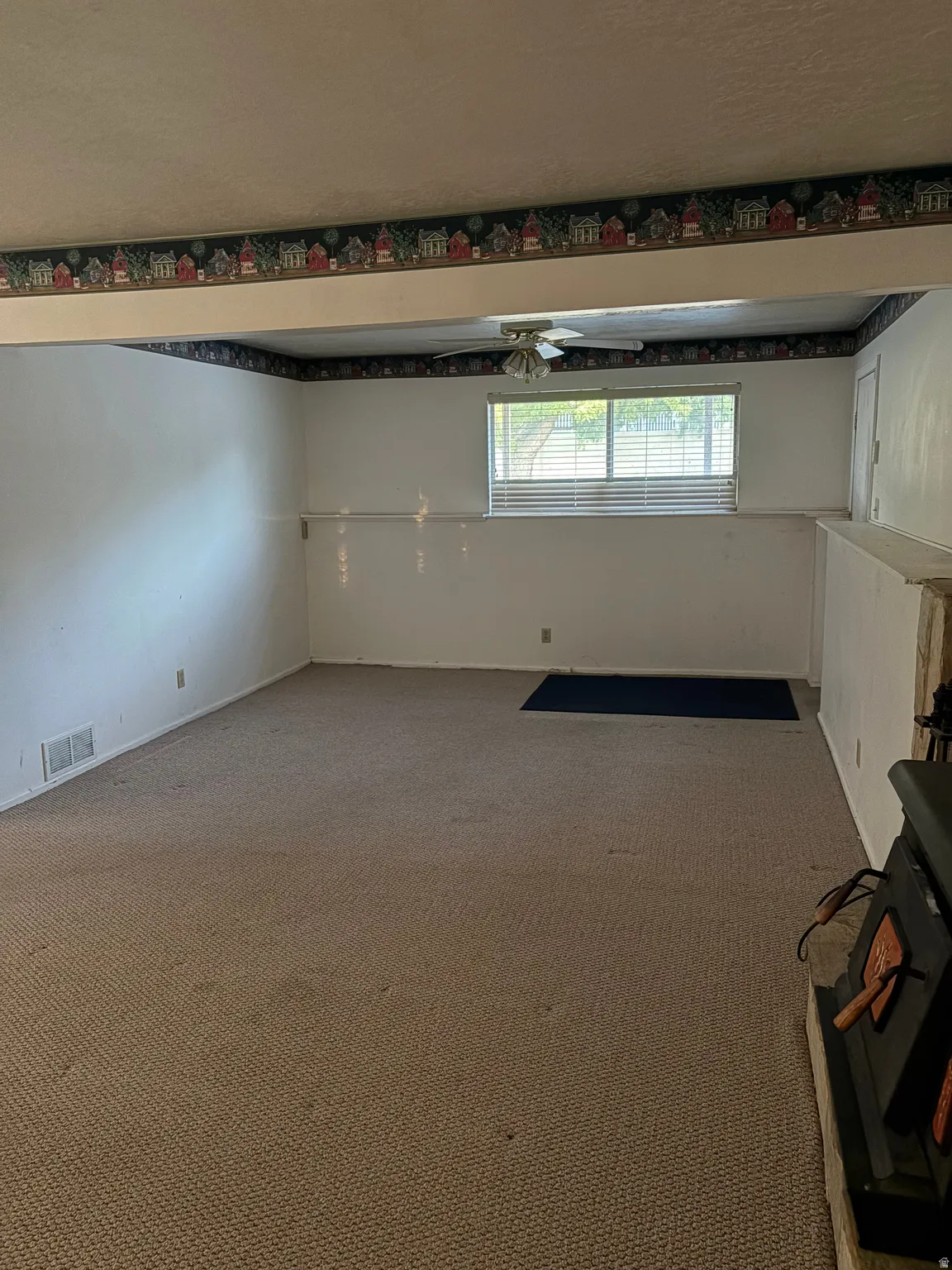 Carpeted flooring, white painted walls, and a ceiling fan with light fixture
