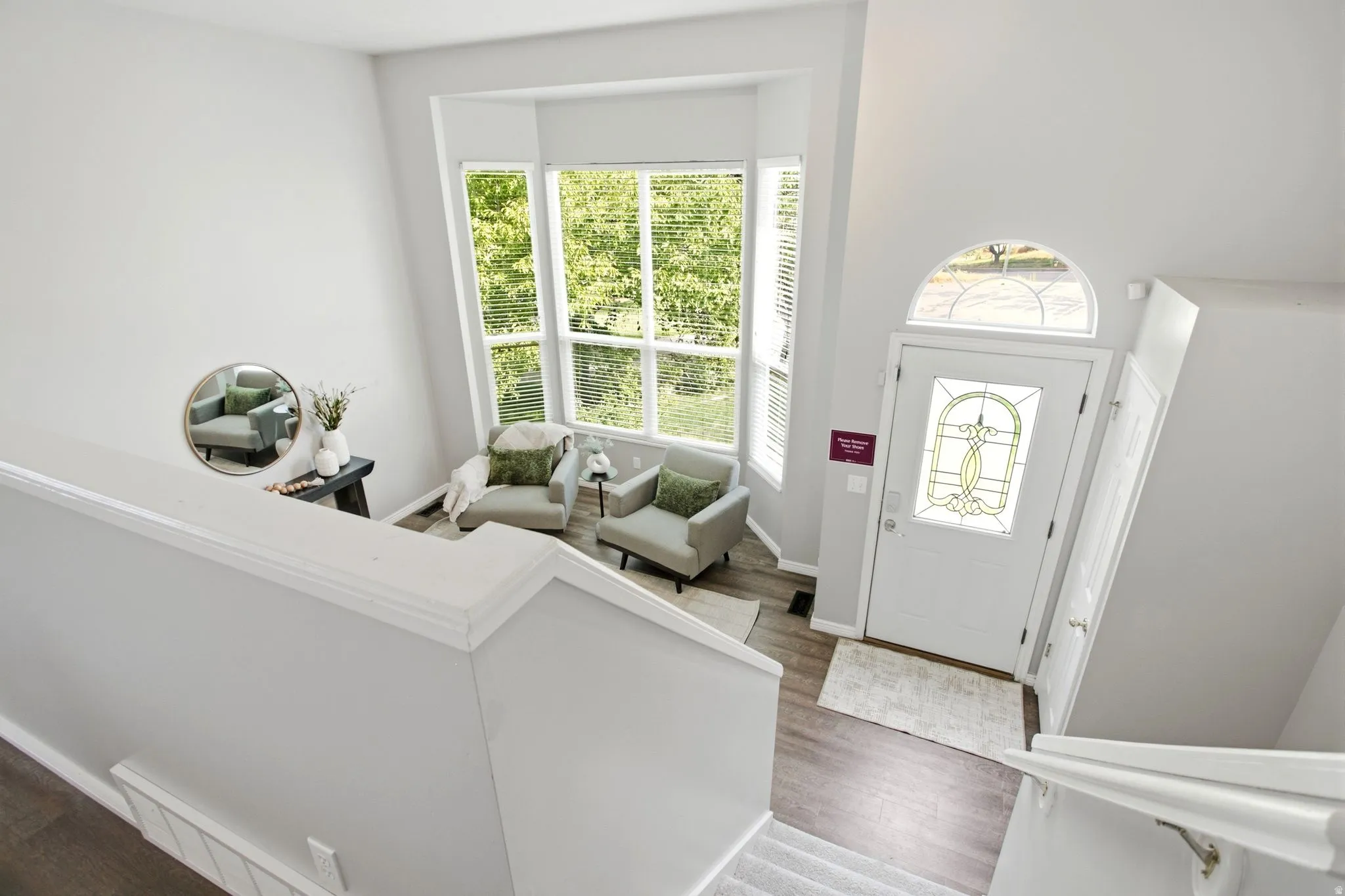 Foyer featuring a decorative glass front door with an arched transom, multi-panel windows, and wood-finish flooring
