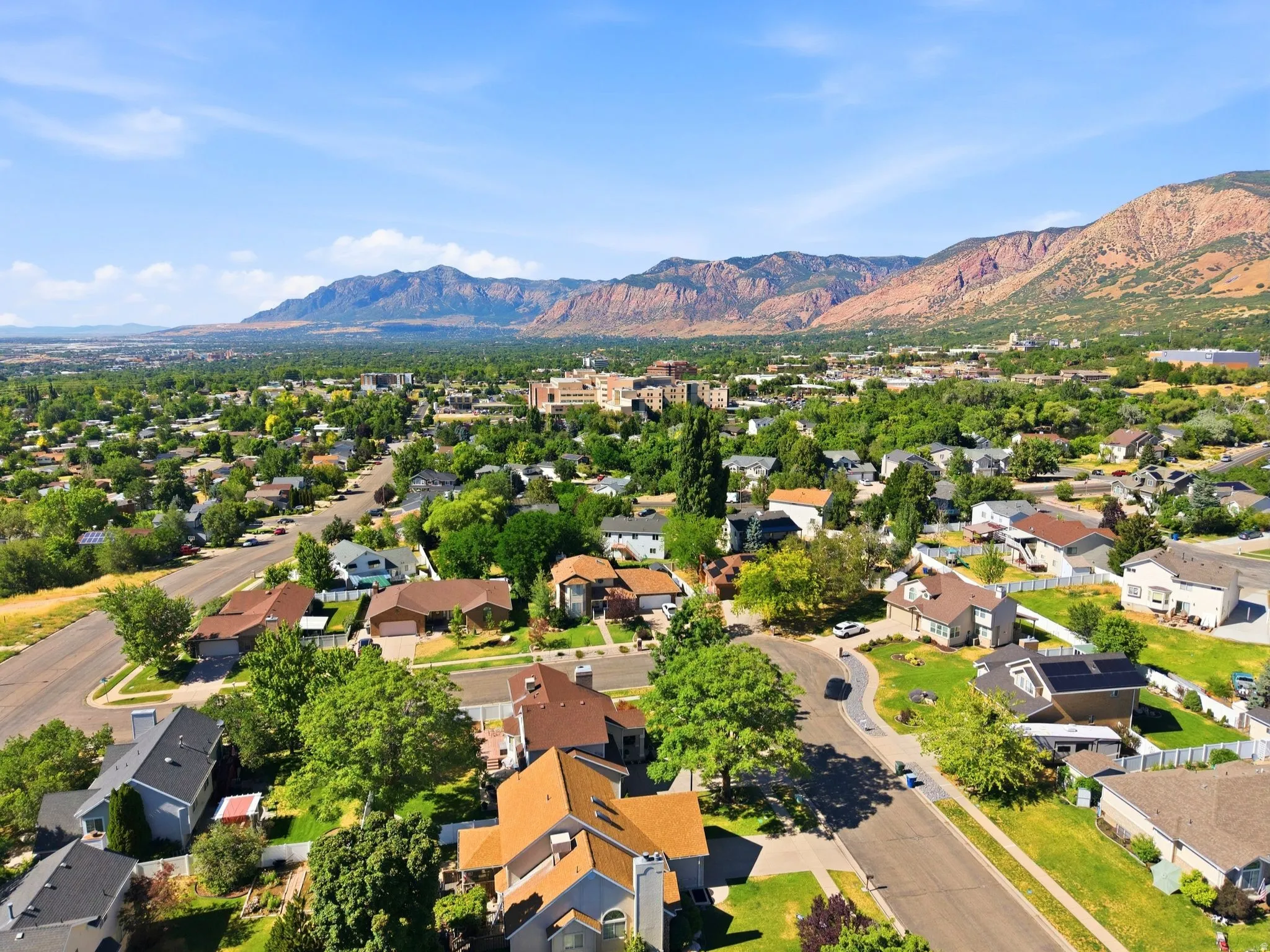 Expansive residential area featuring numerous single-family homes with diverse architectural styles, mature trees, and paved streets