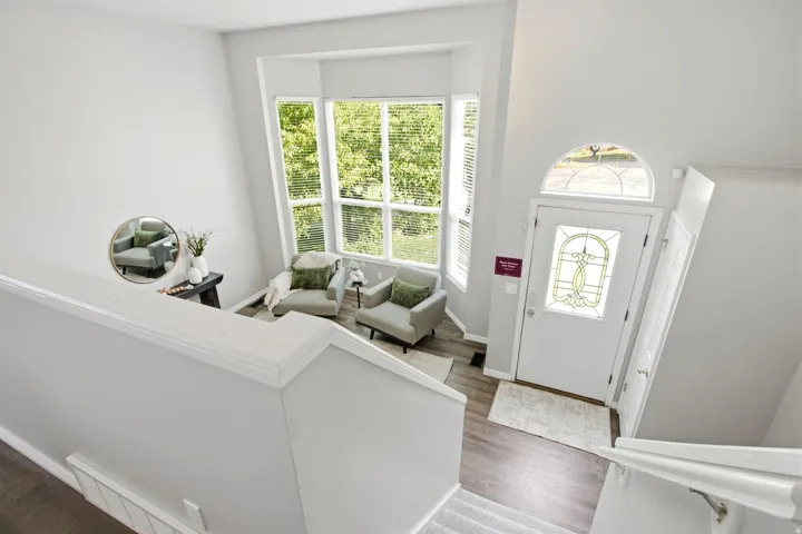 Foyer featuring a decorative glass front door with an arched transom, multi-panel windows, and wood-finish flooring