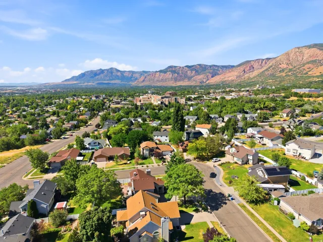 Expansive residential area featuring numerous single-family homes with diverse architectural styles, mature trees, and paved streets