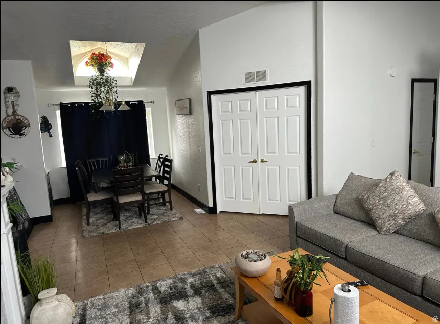 Open-concept living space featuring vaulted ceilings and tile flooring