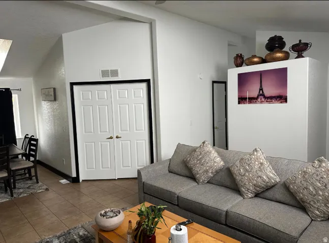 Open-concept living space featuring vaulted ceilings and neutral-toned walls
