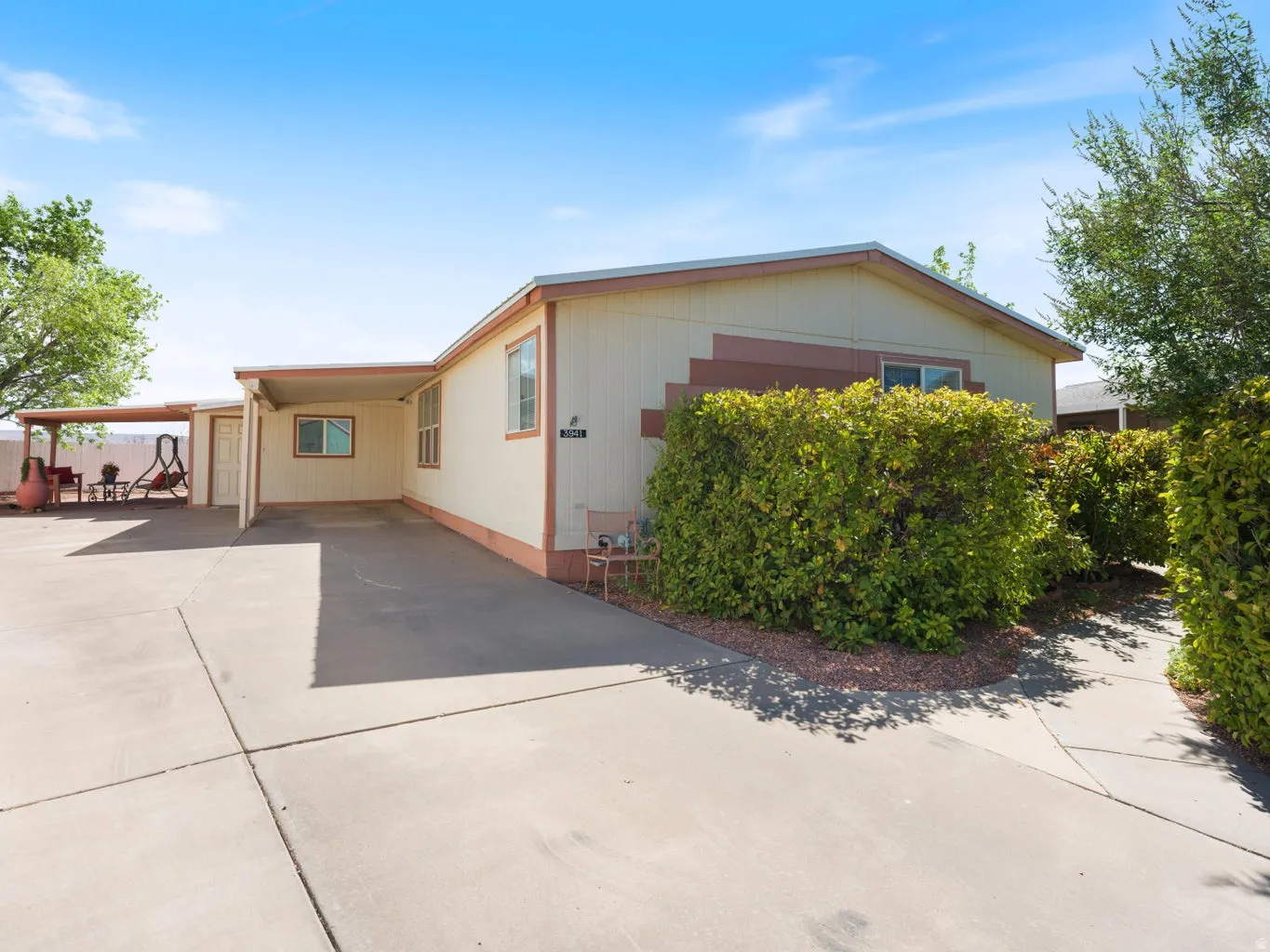 Exterior features a covered carport, an additional covered patio area, and mature shrubbery