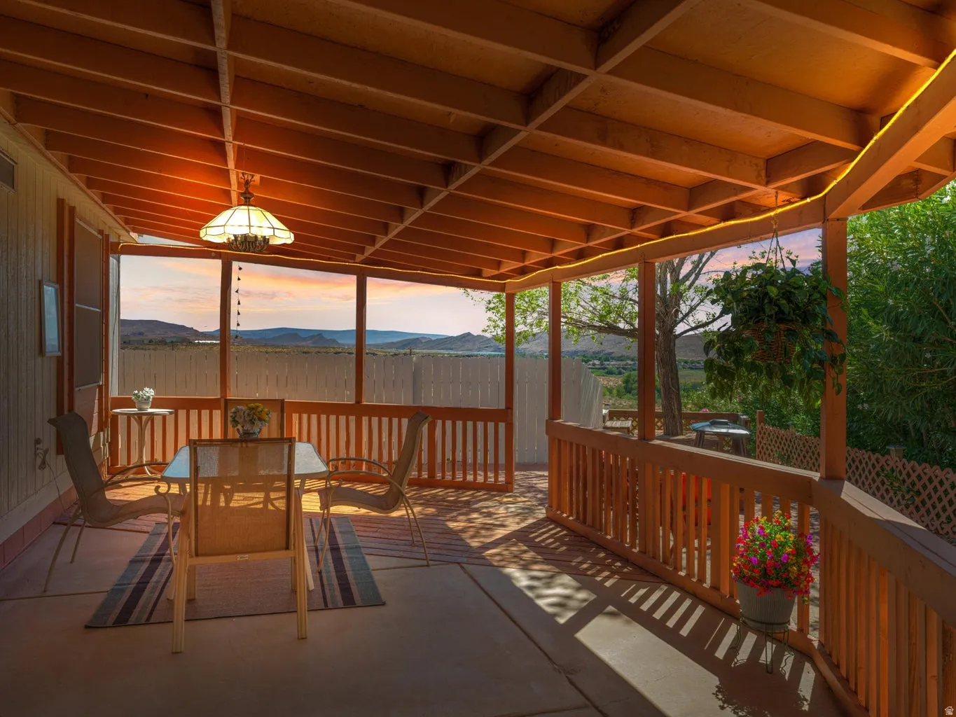 Covered patio featuring a wood-beam ceiling, exposed rafters, and an overhead light fixture