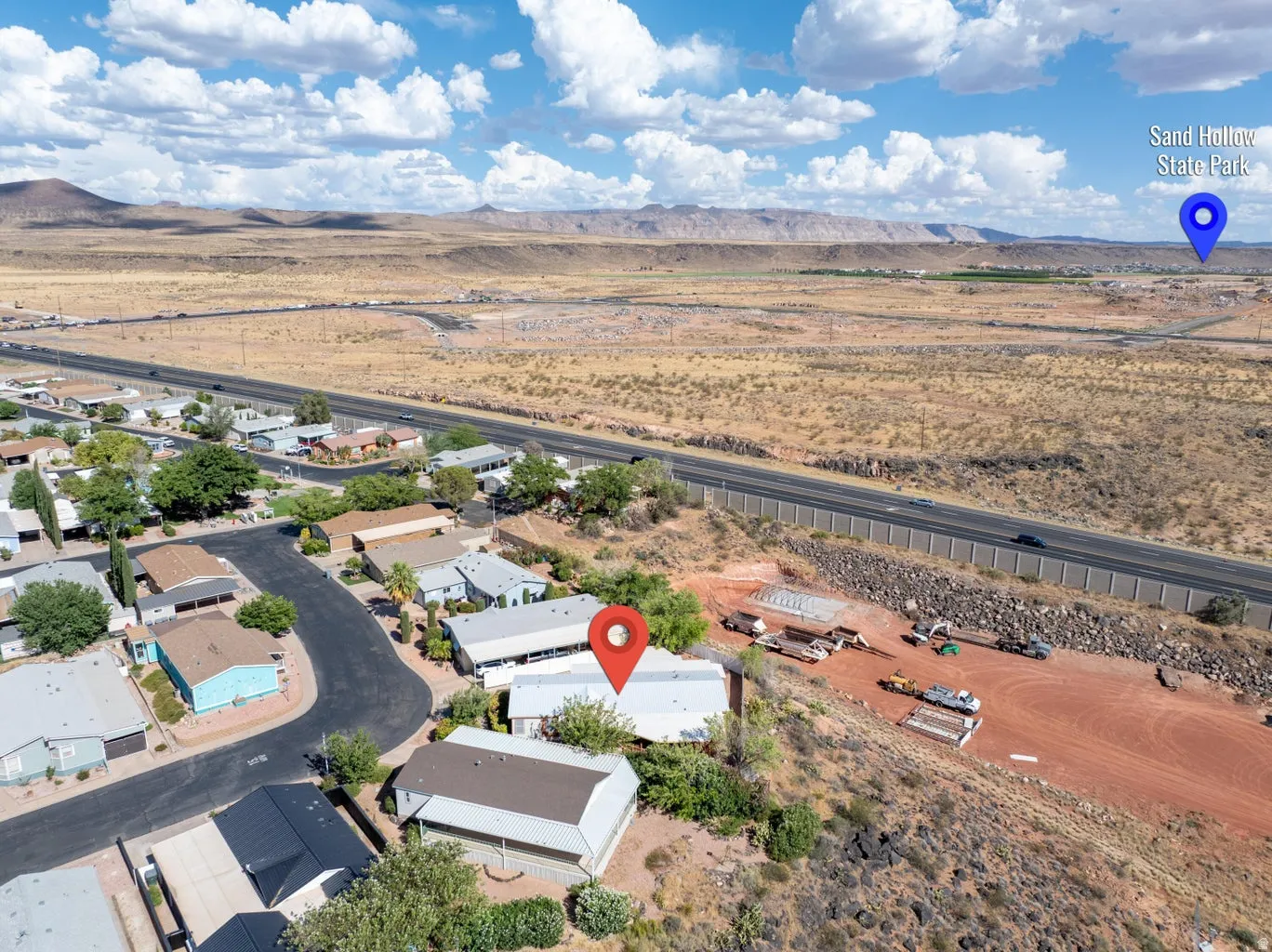 Aerial view showcasing a residential area bordered by a highway and expansive desert landscape