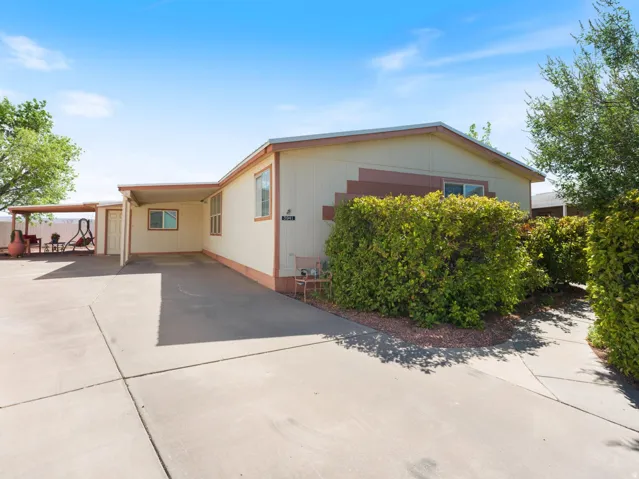 Exterior features a covered carport, an additional covered patio area, and mature shrubbery