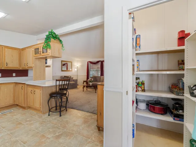 Kitchen featuring wood cabinetry, light-toned countertops, and tile flooring