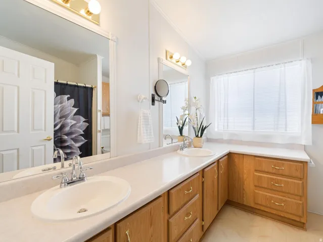 Dual vanity with integrated sinks and chrome fixtures, complemented by a light-toned countertop
