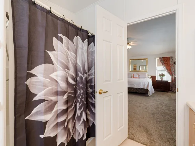 Interior space featuring a white six-panel door with brass hardware and light brown carpeting