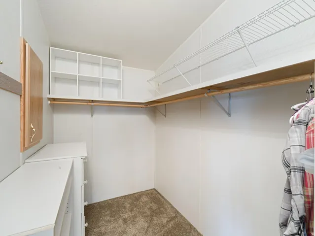 Walk-in closet featuring built-in shelving, hanging rods, and an integrated dresser with drawers