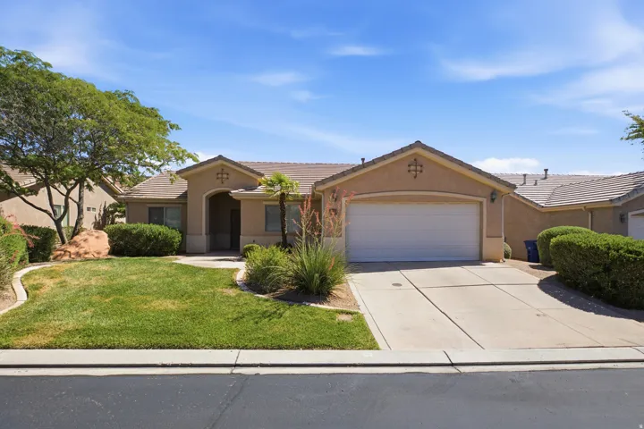 Southwestern-style residence featuring a stucco exterior, a two-car garage, and a tiled roof