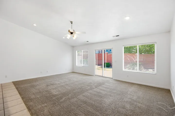 Spacious room featuring vaulted ceilings, recessed lighting, and a ceiling fan