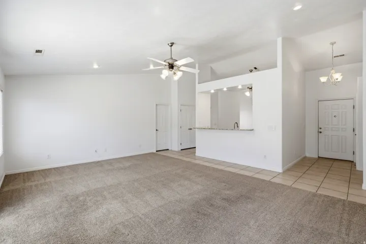 Spacious living area featuring neutral carpeting and white wall finishes