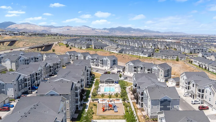 Aerial perspective showcasing a residential community with multiple multi-story buildings featuring grey siding and dark roofs