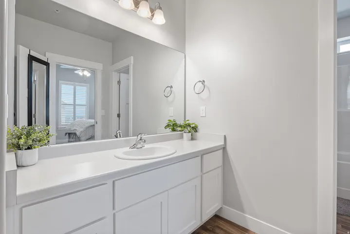 Vanity with white cabinetry, a single basin sink, and a chrome faucet