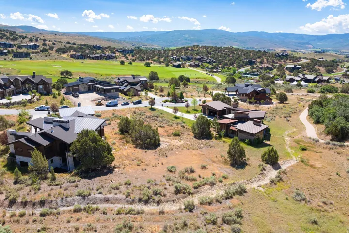 Expansive property featuring multiple contemporary residences, natural landscaping, and golf course access