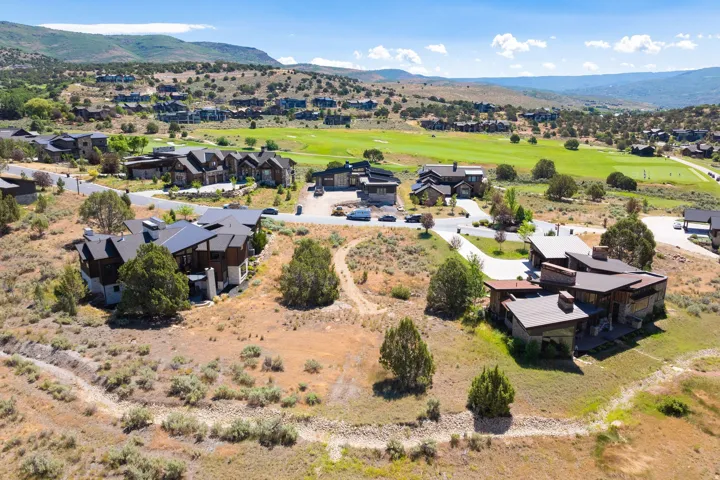 Contemporary residence with multi-level rooflines, extensive natural landscaping, and golf course access