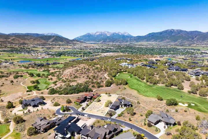 Expansive undeveloped lot featuring a defined boundary, surrounded by established residential properties and natural landscaping