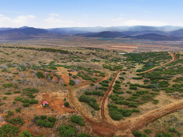 Expansive, undeveloped terrain with a single structure featuring a red roof