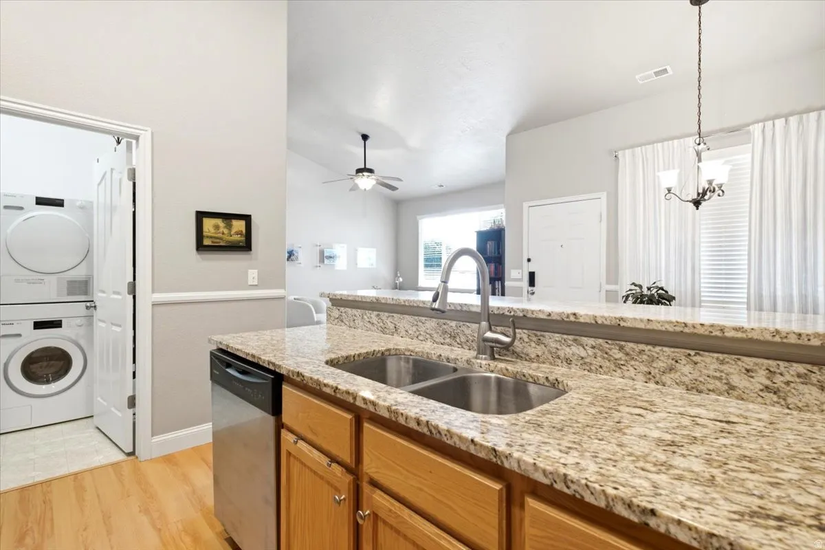 Kitchen featuring granite countertops, wood cabinetry, and a dual basin stainless steel sink with a gooseneck faucet