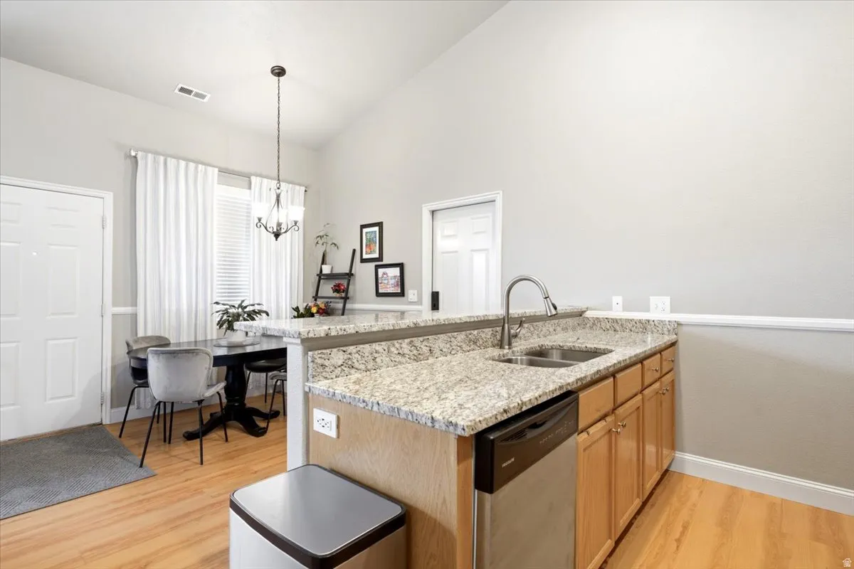 Kitchenette with granite countertops and an undermount double basin sink featuring a gooseneck faucet