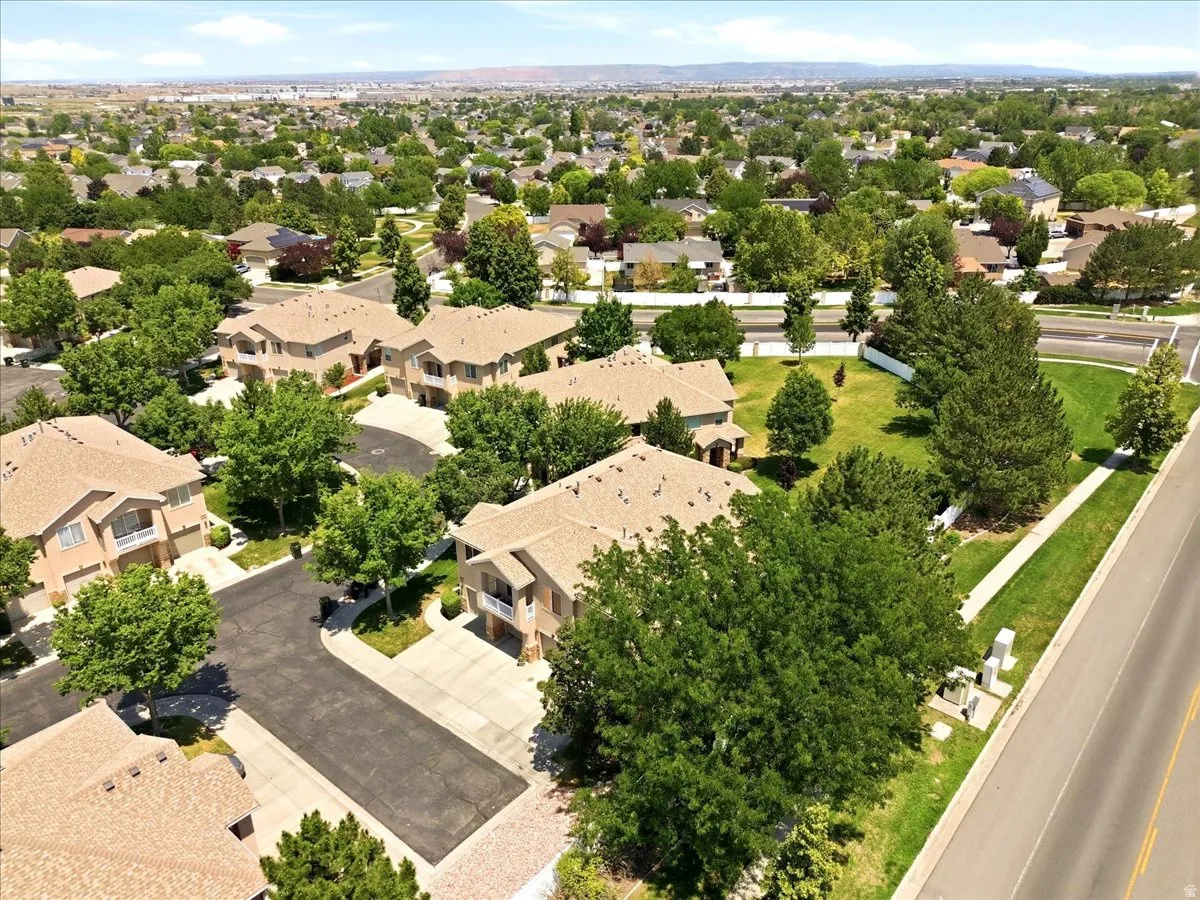 Expansive suburban landscape featuring numerous properties with light-toned shingle roofing and mature trees