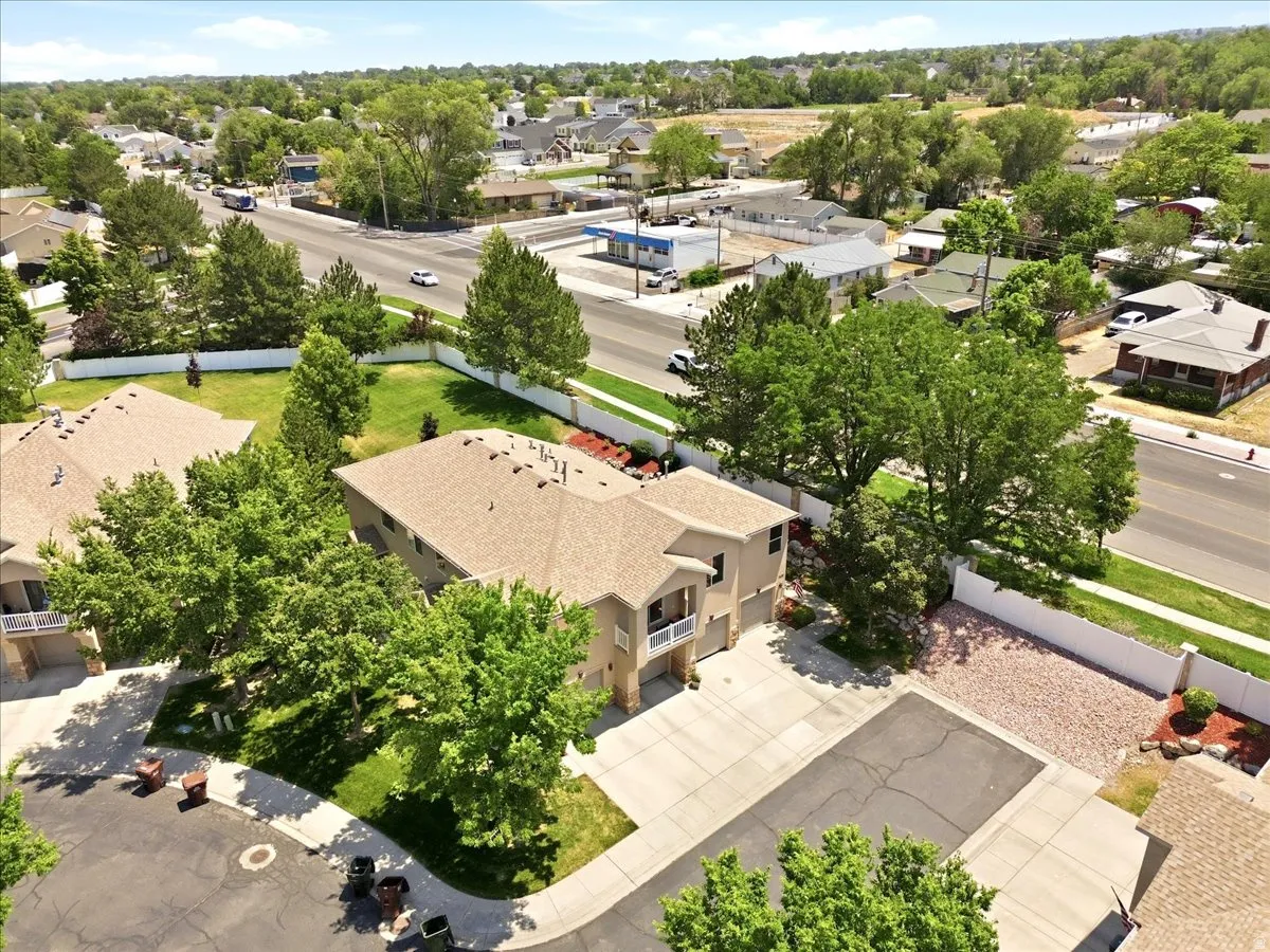 Two-story stucco residence featuring a balcony, attached two-car garage, and a concrete driveway