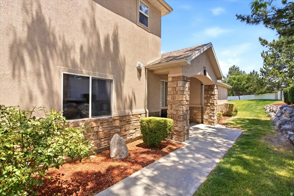 Stone-accented entryway featuring stucco siding