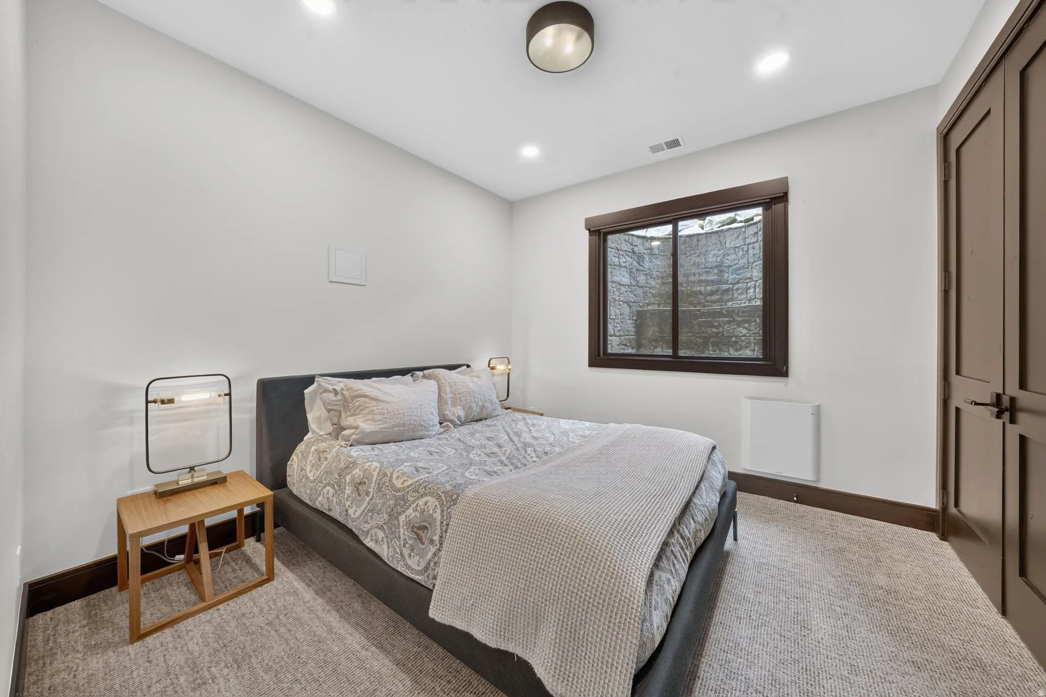 White walls with dark wood trim, recessed lighting, and a carpeted floor