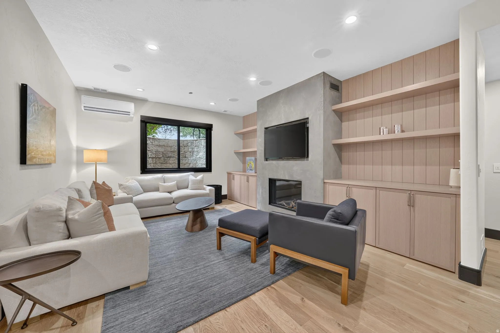 Living space featuring light wood-finish flooring and recessed lighting