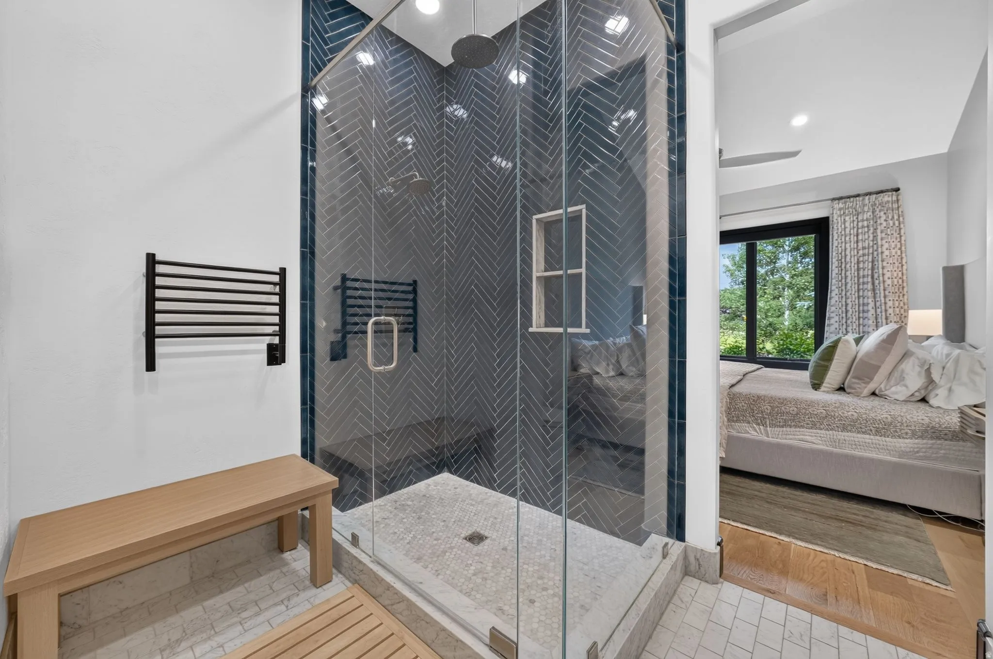 Glass-enclosed shower featuring chevron-patterned wall tile and a built-in niche